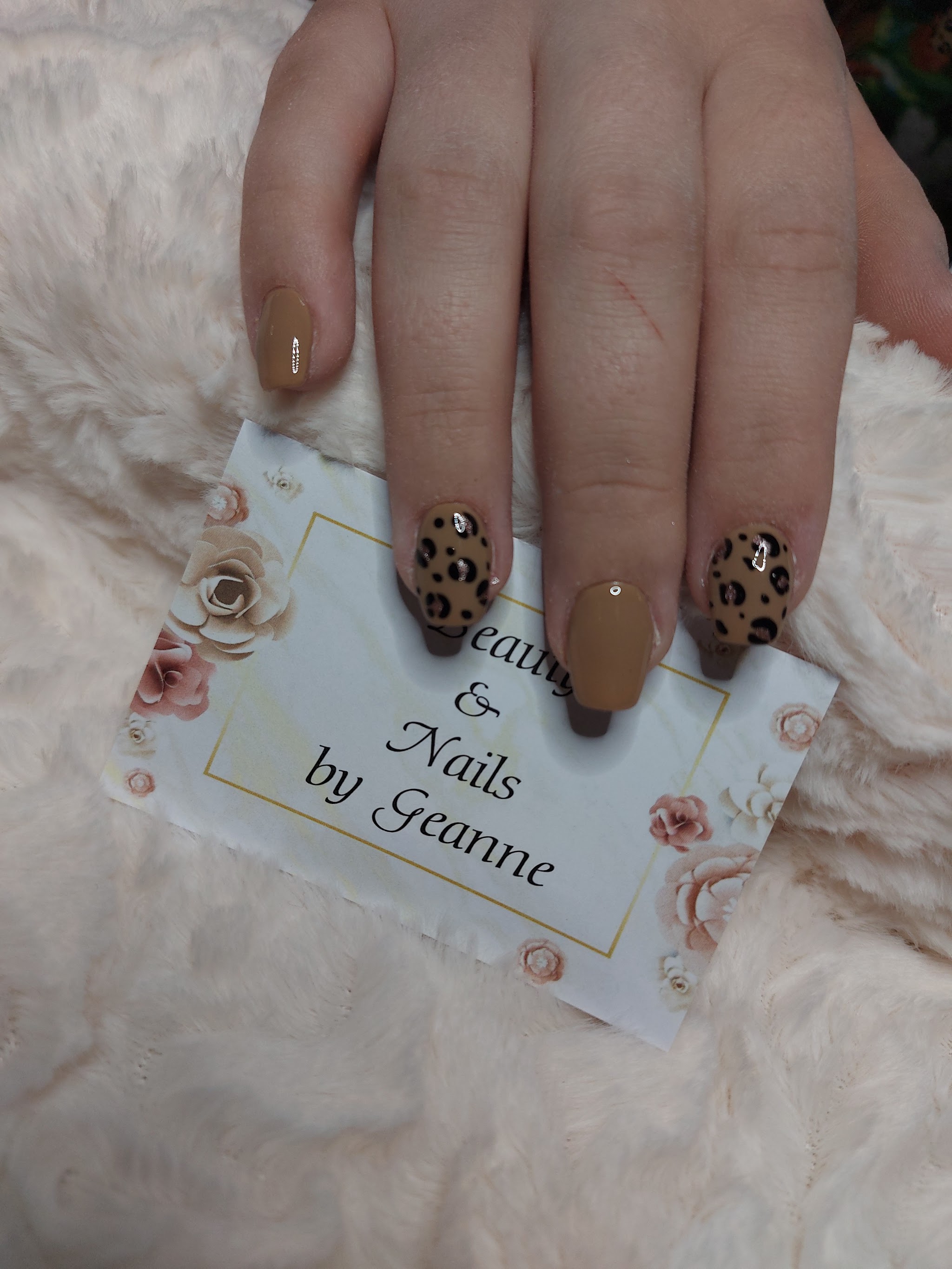 Karamelkleurige nagels met luipaardprint, met het visitekaartje van Beauty and Nails by Geanne