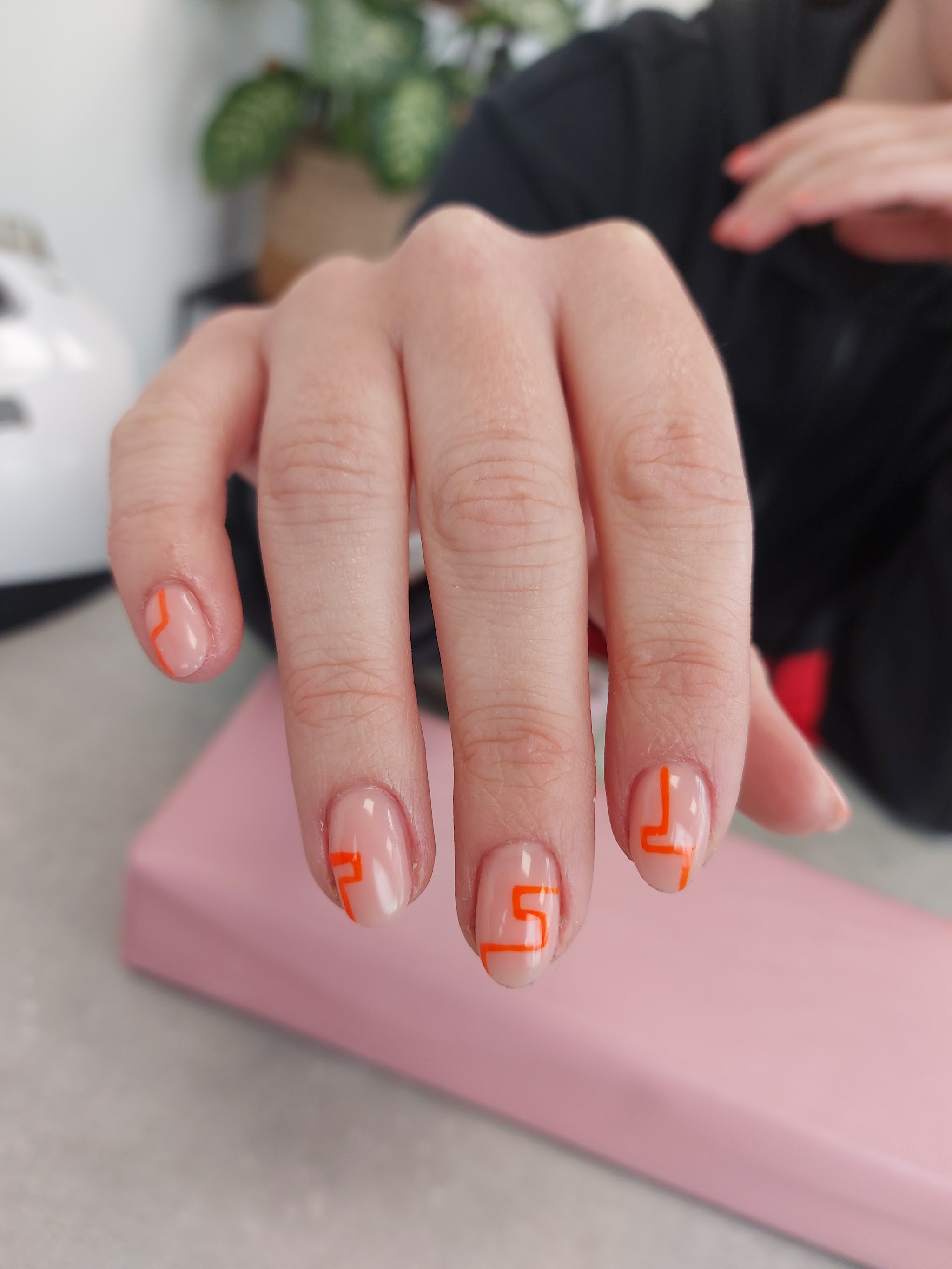 Nude nagels met oranje geometrische lijnen