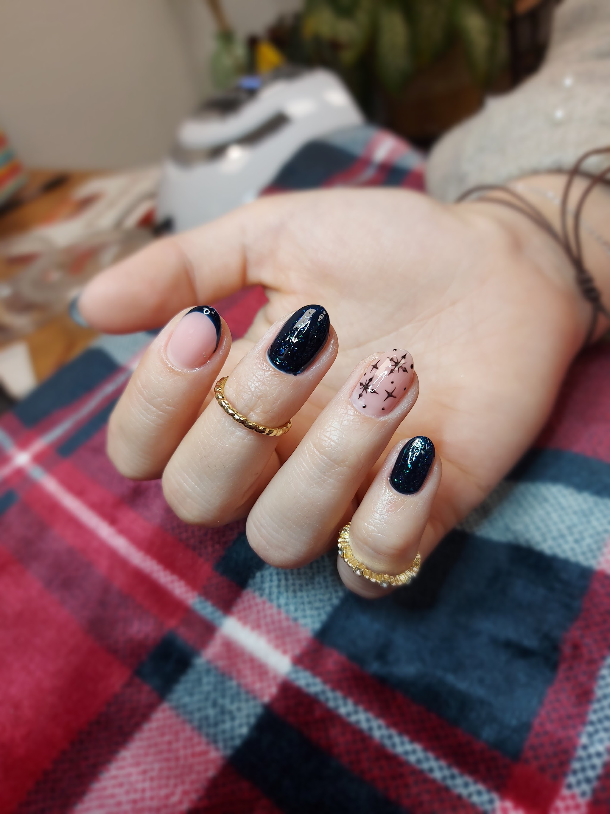 Donkerblauwe glitternagels met een accentnagel met sterretjes
