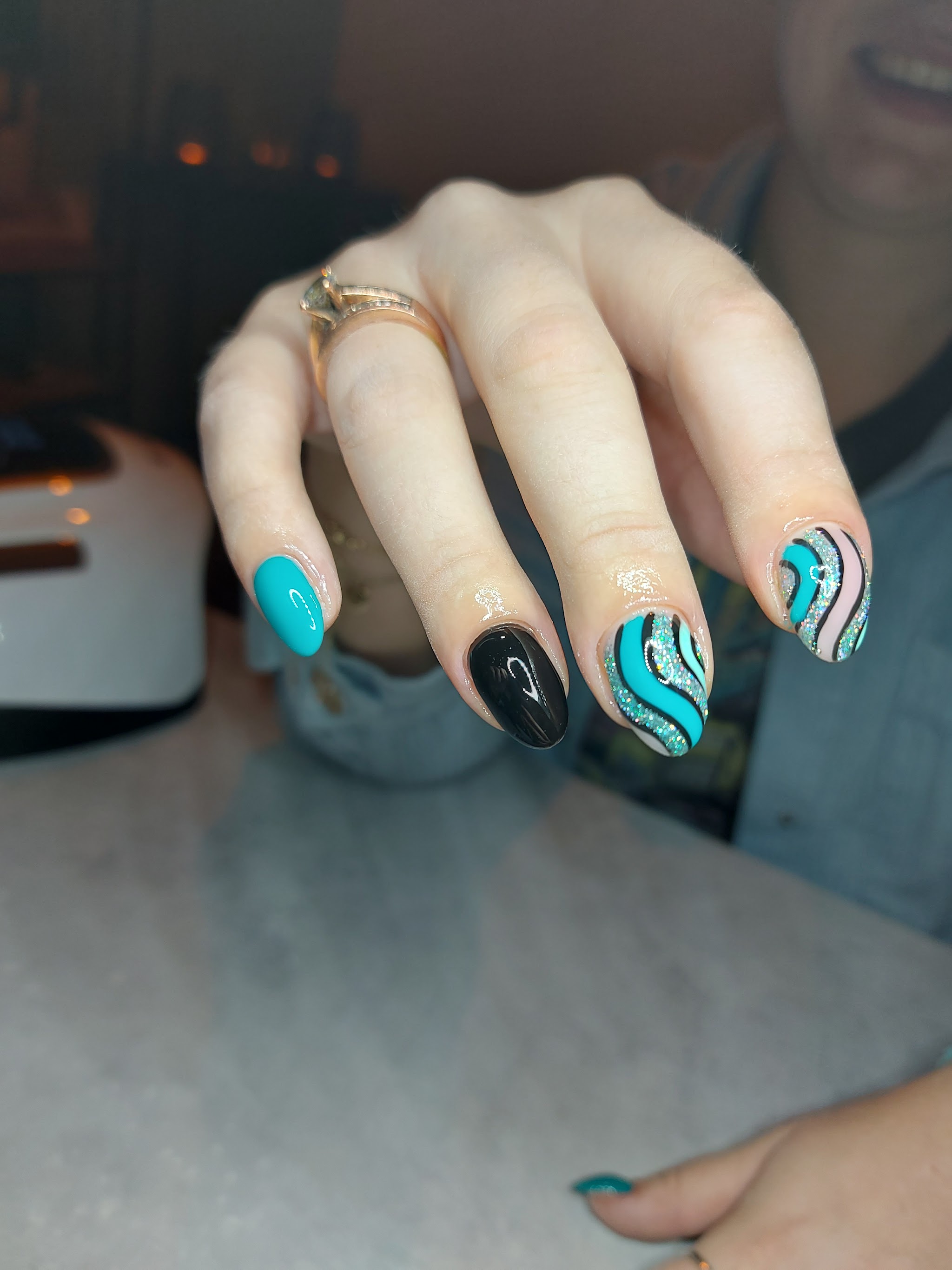 Turquoise en zwarte nagels met zilveren swirls