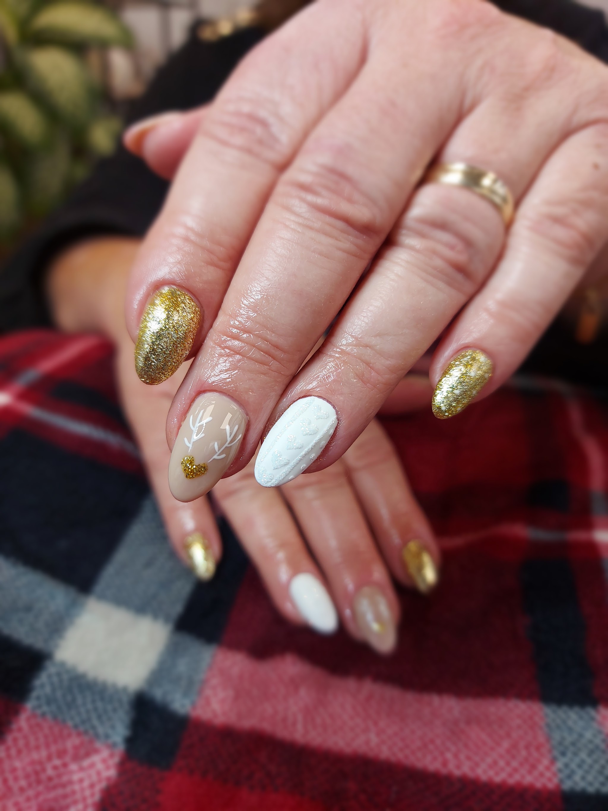 Goudglitter en witte nagels met een gebreide structuur en een gouden hartje