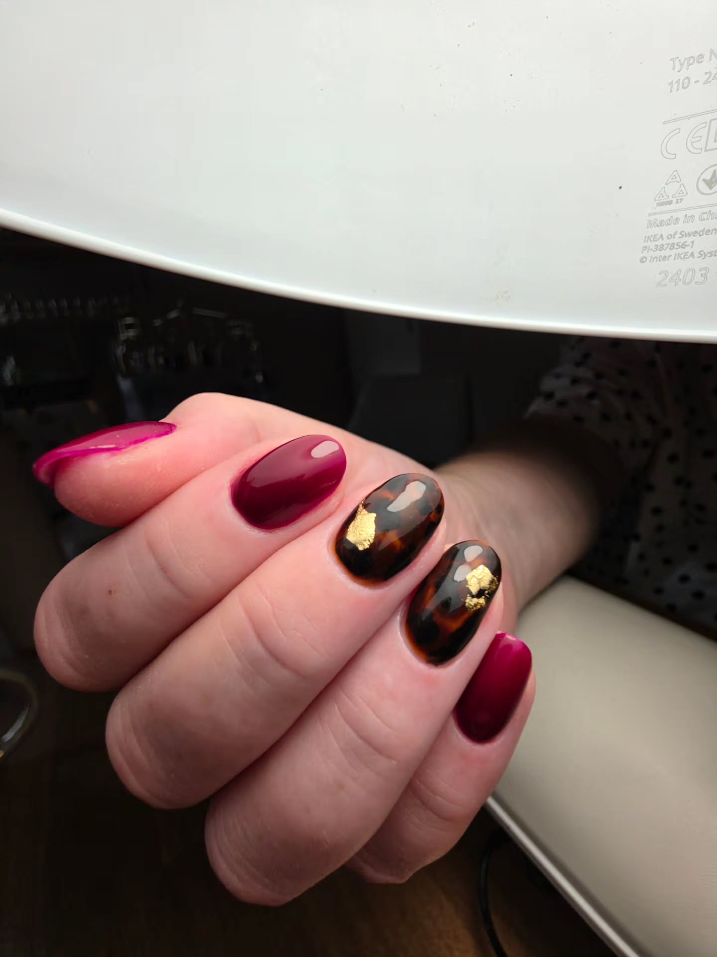 Bordeaux nagels met schildpad- en goudfolie-accenten